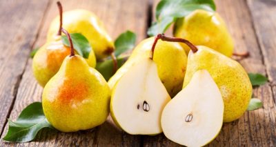 fresh pears with leaves on wooden table